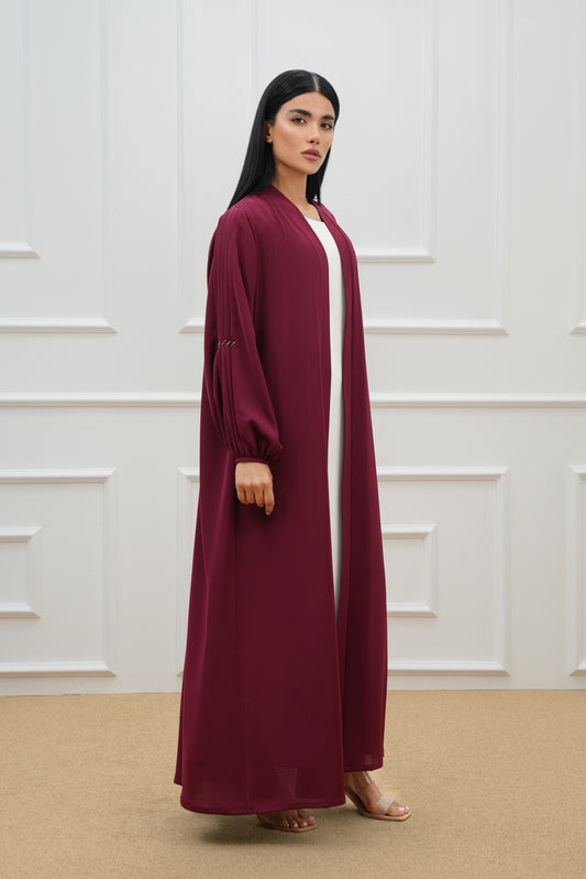 Pleated abaya with embroidered details on the sleeves and back.