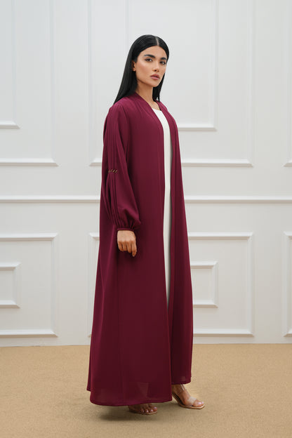 Pleated abaya with embroidered details on the sleeves and back.