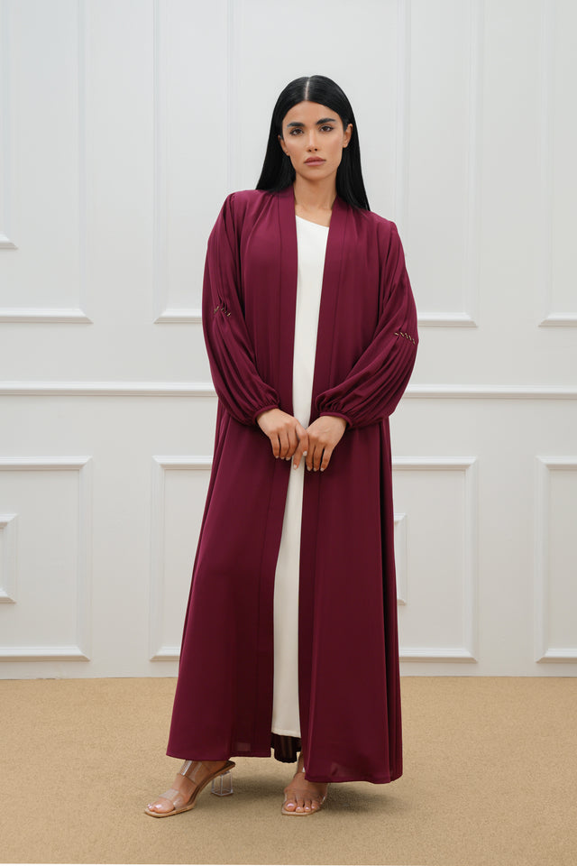 Pleated abaya with embroidered details on the sleeves and back.